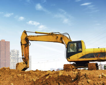 Yellow excavator on a construction site against blue sky