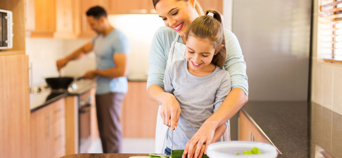 young family preparing meal in kitchen