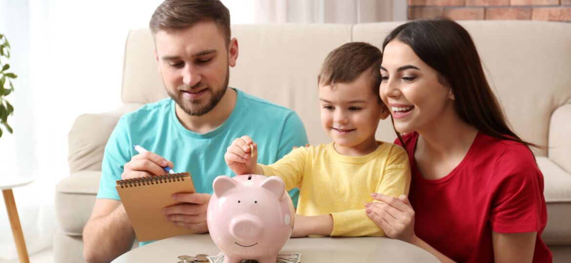 Happy,Family,With,Piggy,Bank,And,Money,At,Home